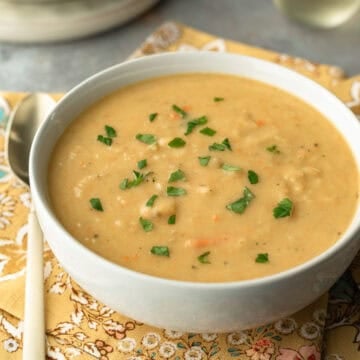 A bowl of dairy free potato soup with a spoon next to it.