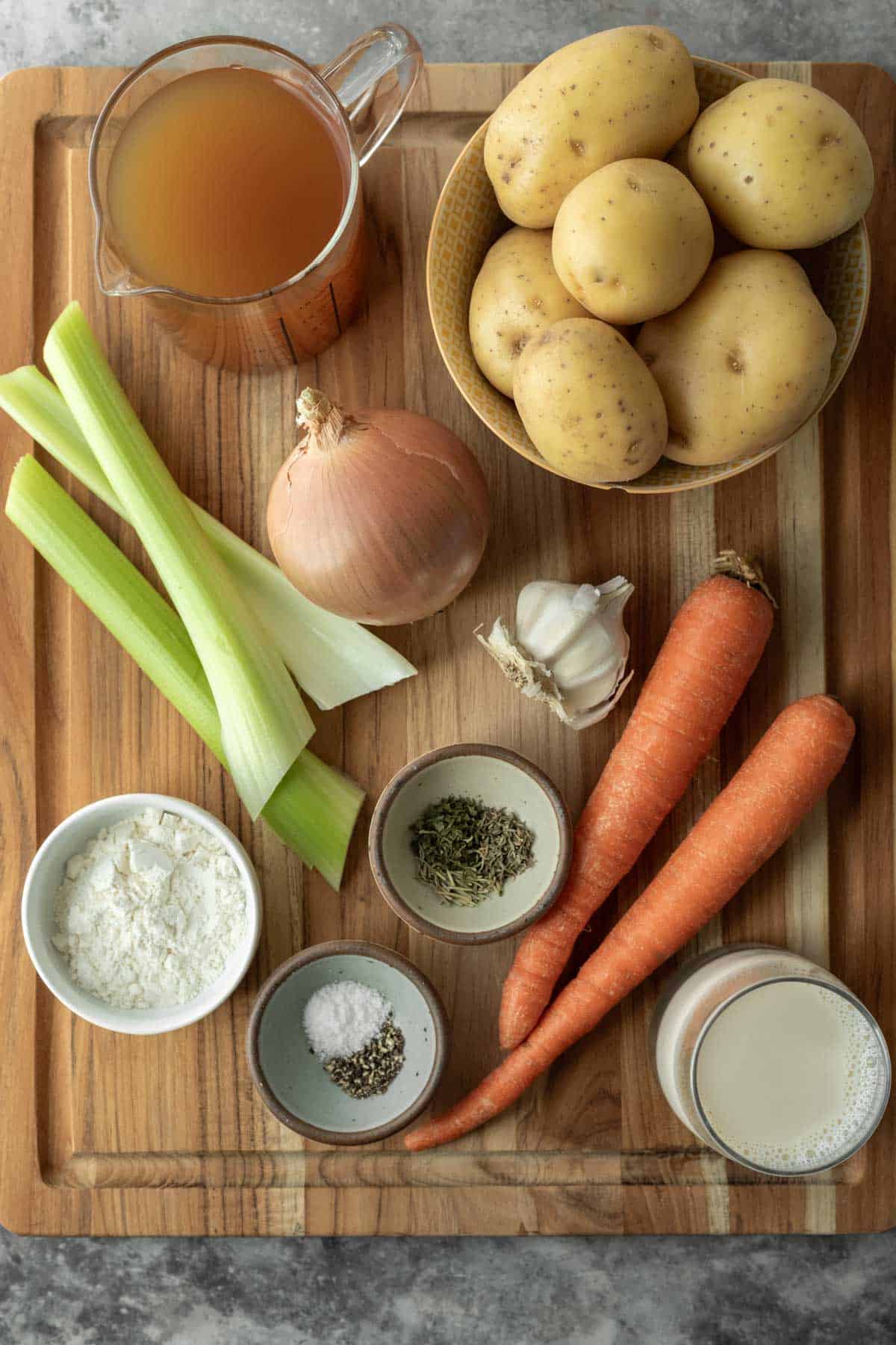 Ingredients for healthy vegan potato soup on a wooden board.