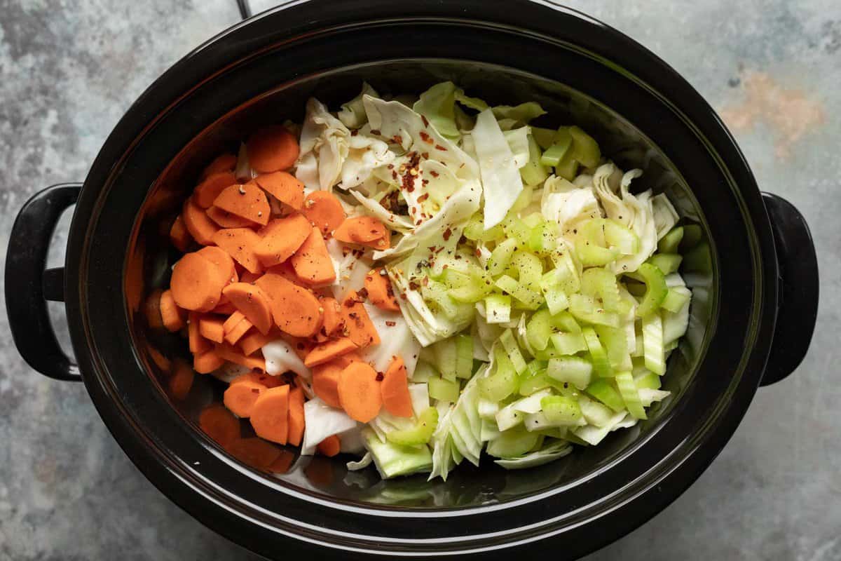 Ingredients for making cabbage soup in a crockpot ready to cook.