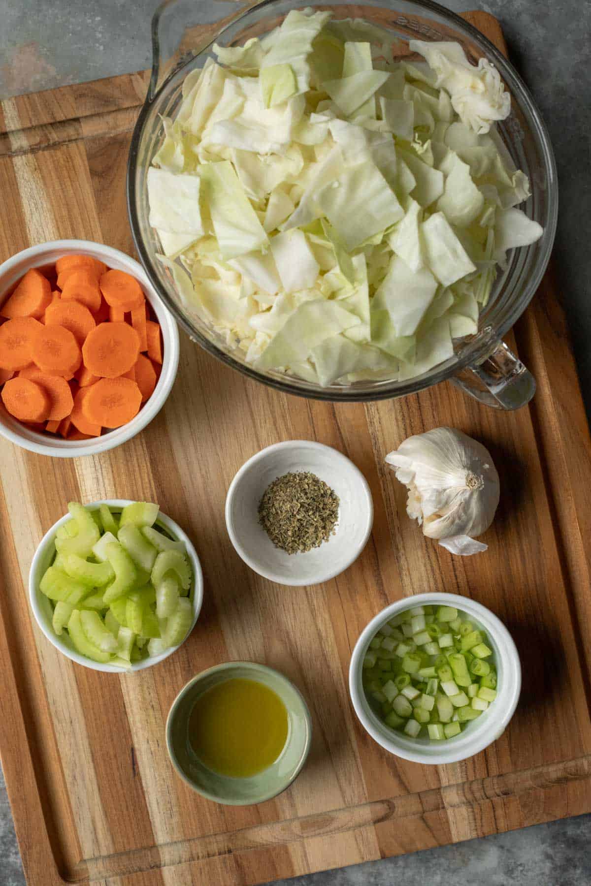 Ingredients for crockpot cabbage soup on a wooden board.