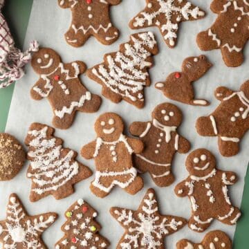 Close-up of decorated almond flour gingerbread cookies on parchment.