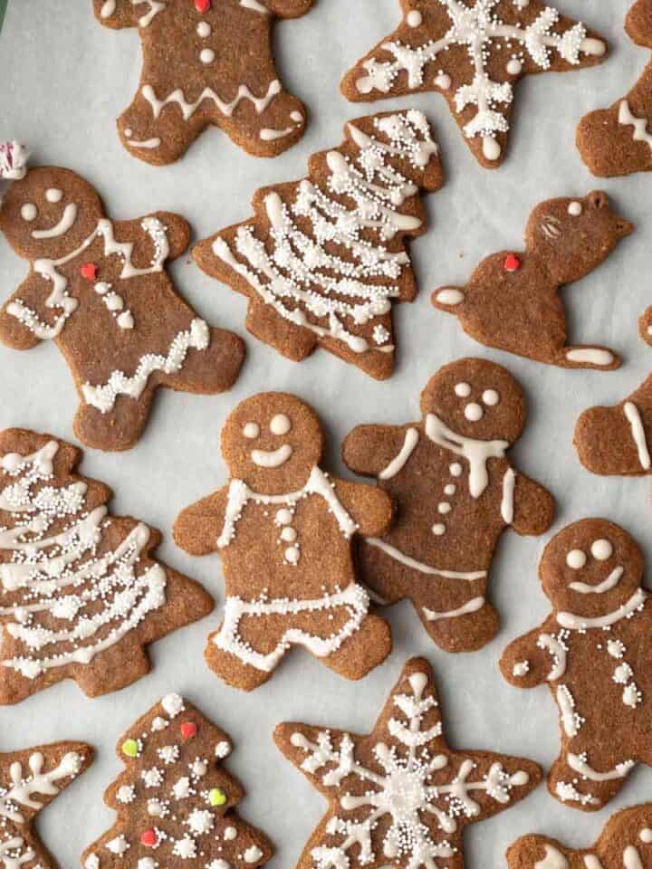 Close-up of decorated almond flour gingerbread cookies on parchment.