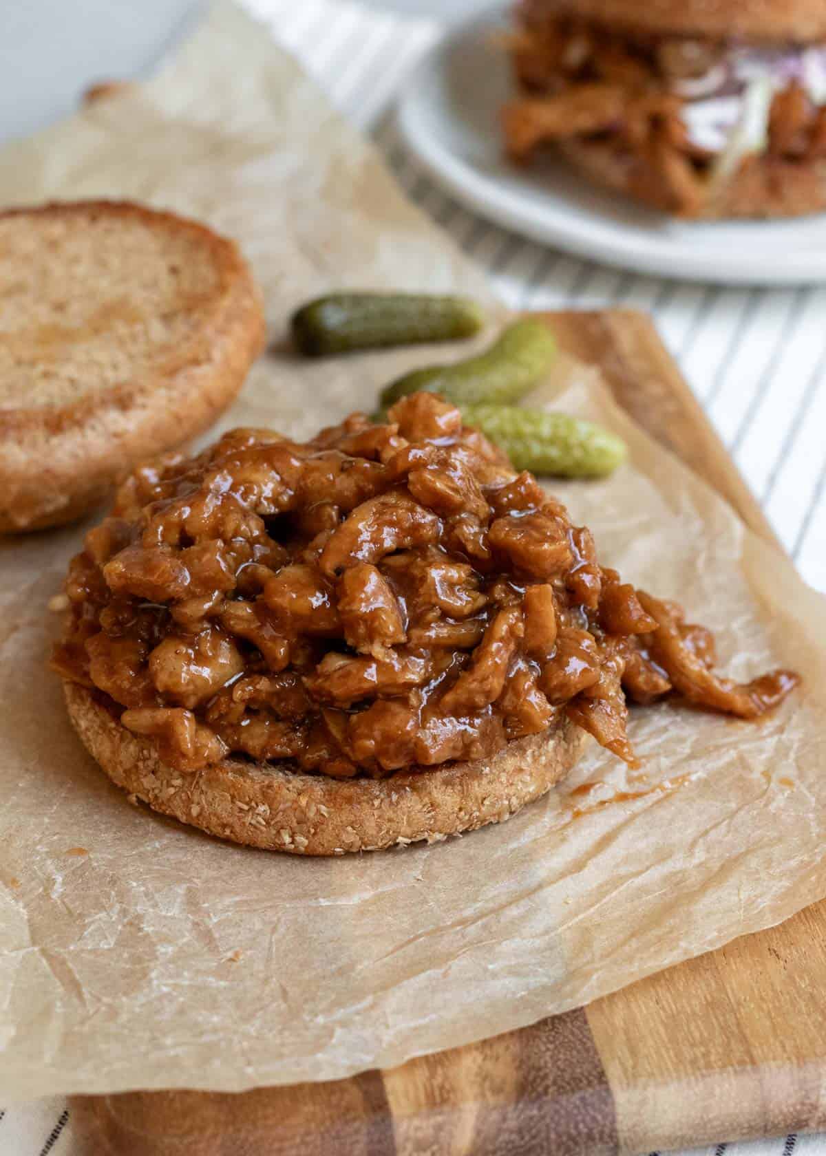 open face sandwich on a bun showing the texture of BBQ soy curls.