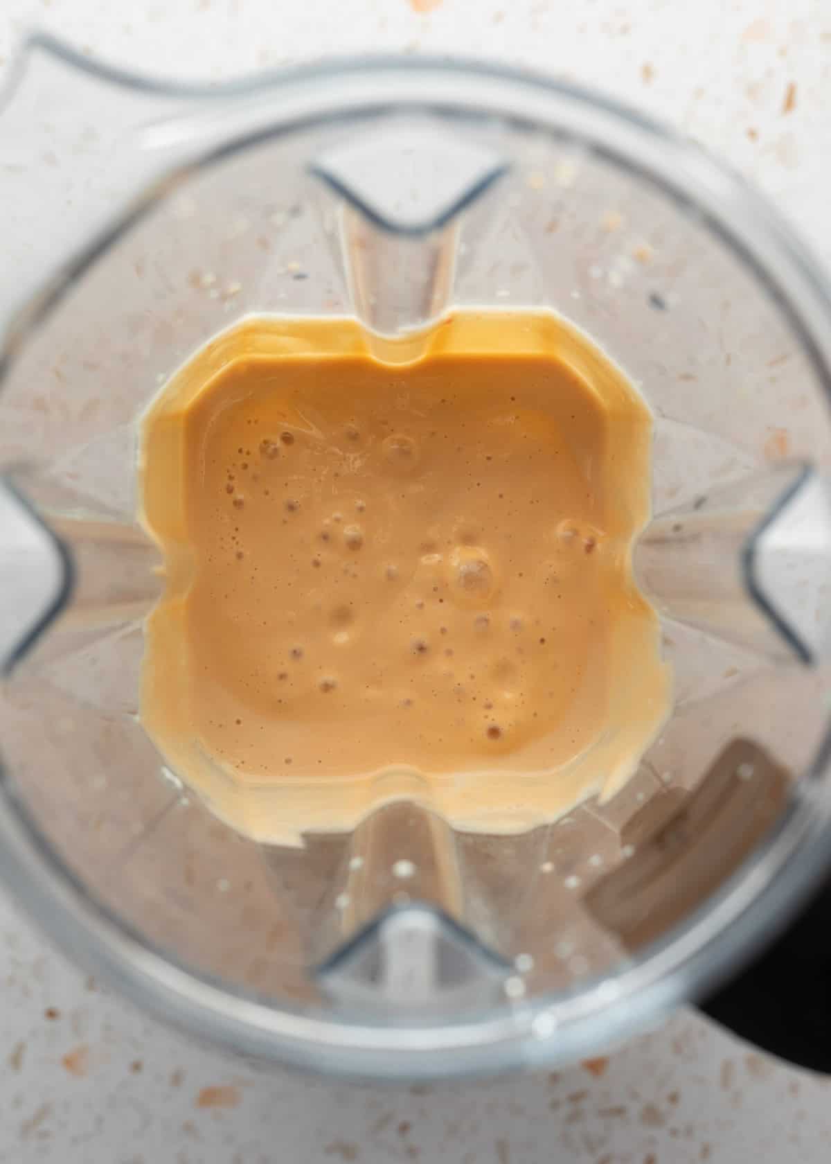 Looking inside the blender at the creamy blended tofu sauce.