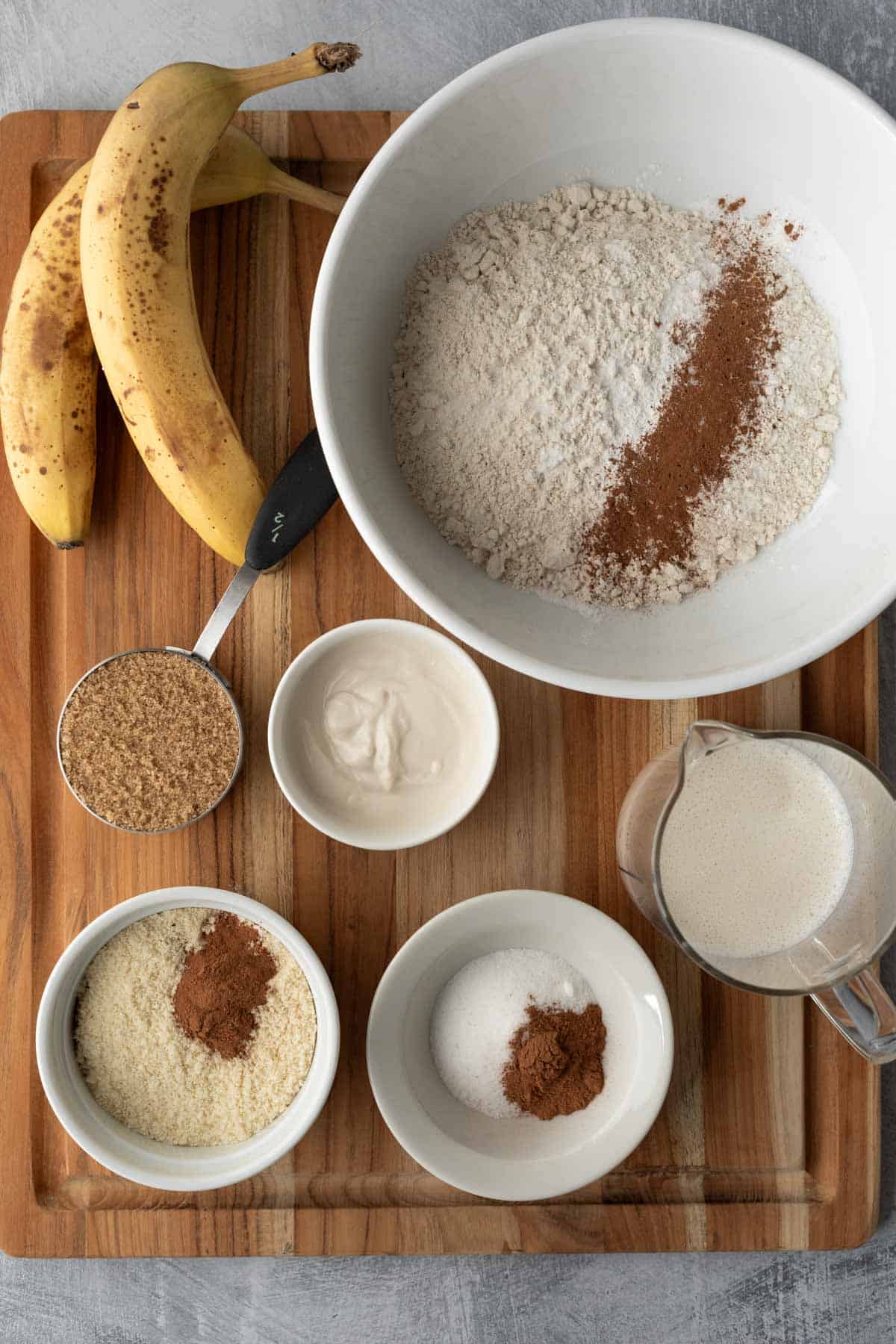 Ingredients for banana coffee cake muffins arranged on a wooden board.