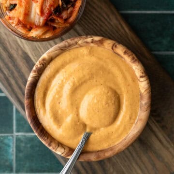 Creamy kimchi dressing in a small bowl with a spoon.