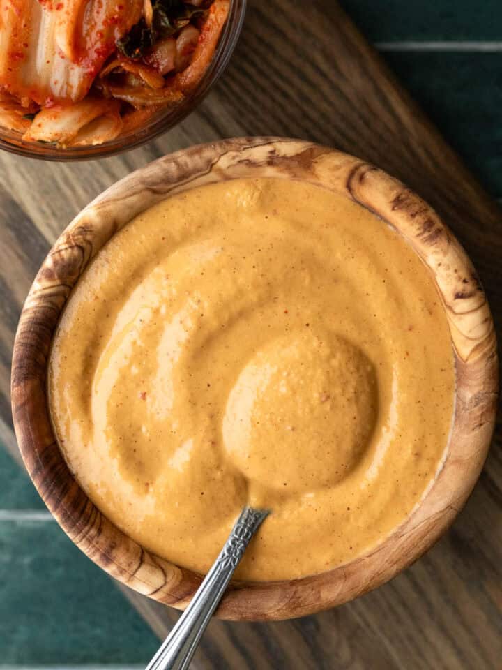 Creamy kimchi dressing in a small bowl with a spoon.