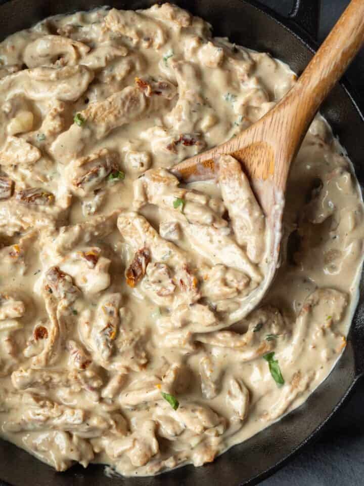 Soy curls coated in a creamy sauce inside a skillet.