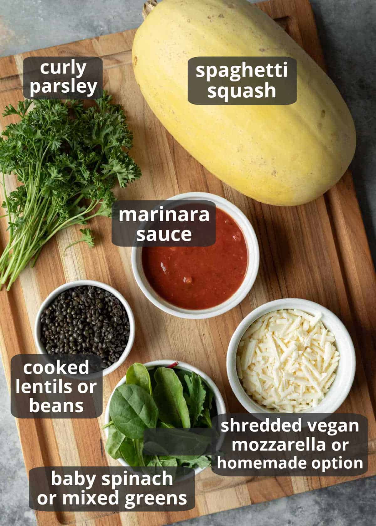 Labeled ingredients for stuffed spaghetti squash arranged on a wooden board.