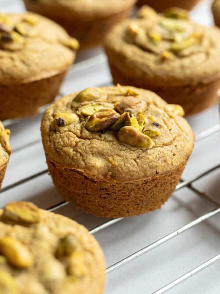 Vegan pistachio muffins on a cooling rack.