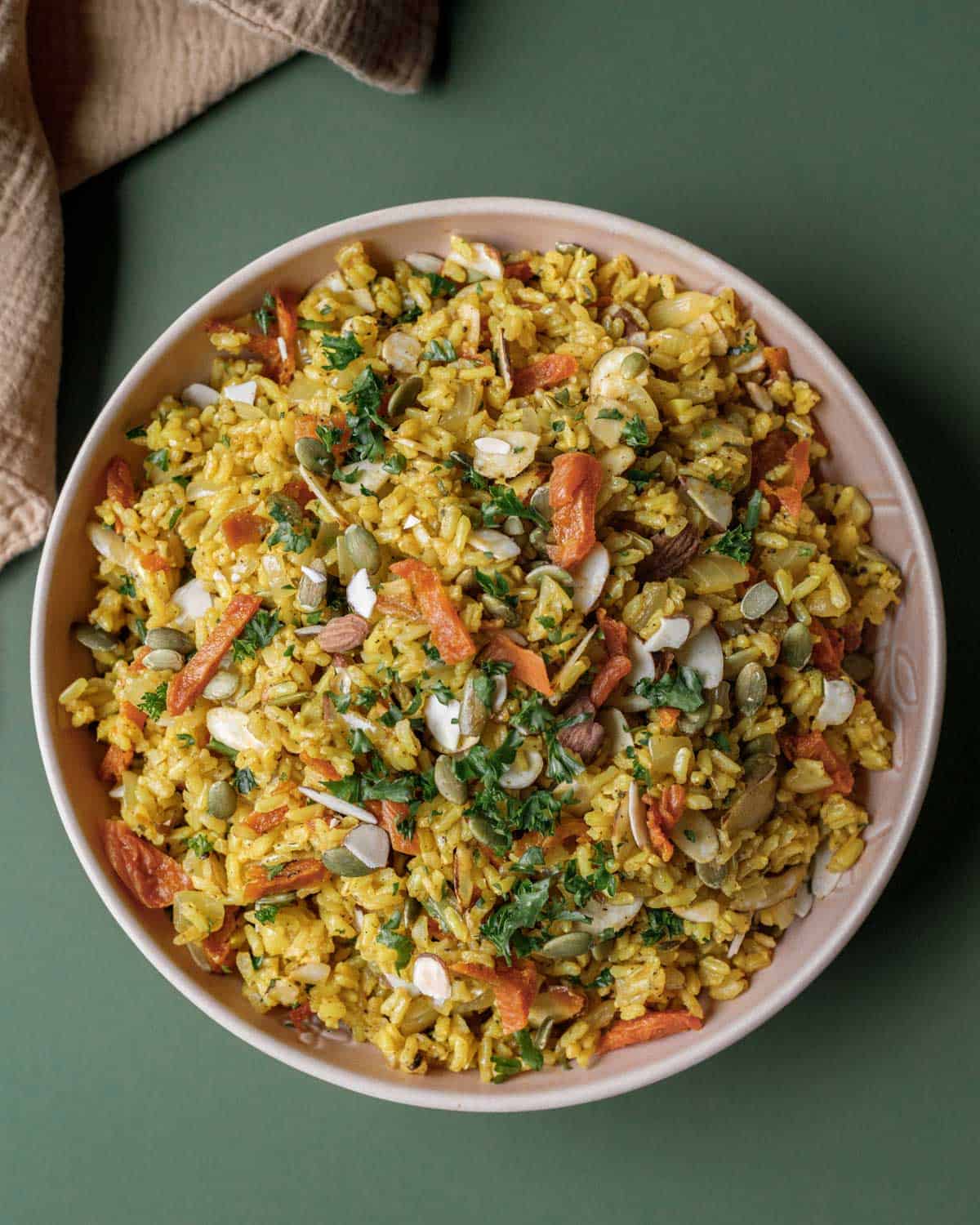 A bowl full of Mediterranean inspired rice pilaf with herbs, turmeric and almonds.