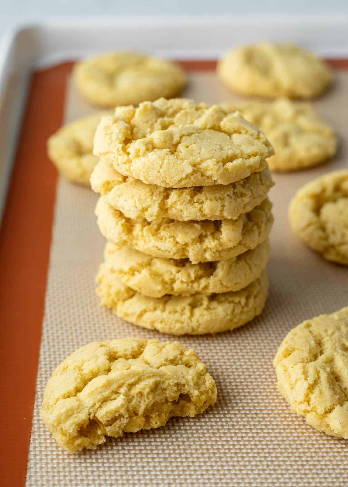A stack of crisp cornmeal cookies that have a pale yellow color from cornflour and olive oil.