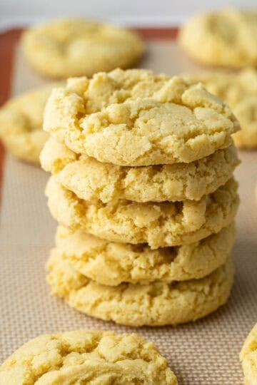 A stack of crispy corn flour cookies on a baking mat.
