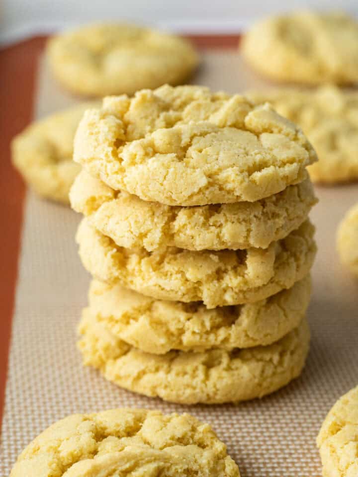 A stack of crispy corn flour cookies on a baking mat.