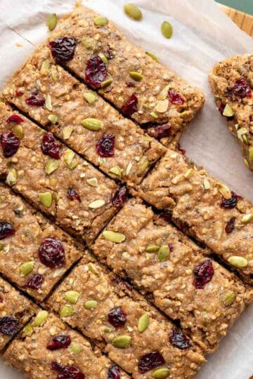 Buckwheat bars with pumpkin seeds and dried cranberries pressed into the tops.