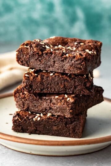 A stack of four fudgy buckwheat brownies on a small plate.