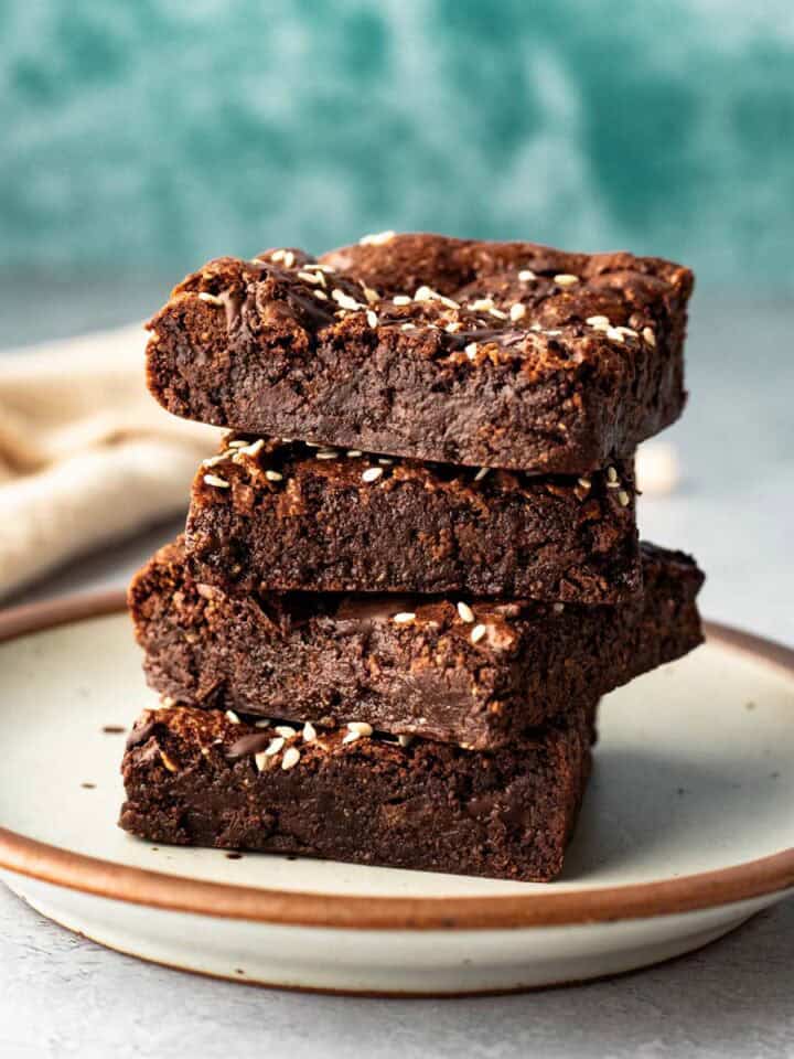 A stack of four fudgy buckwheat brownies on a small plate.