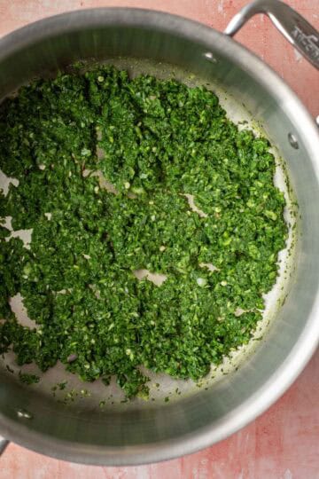 Sauteing the chopped spinach mixture in oil.