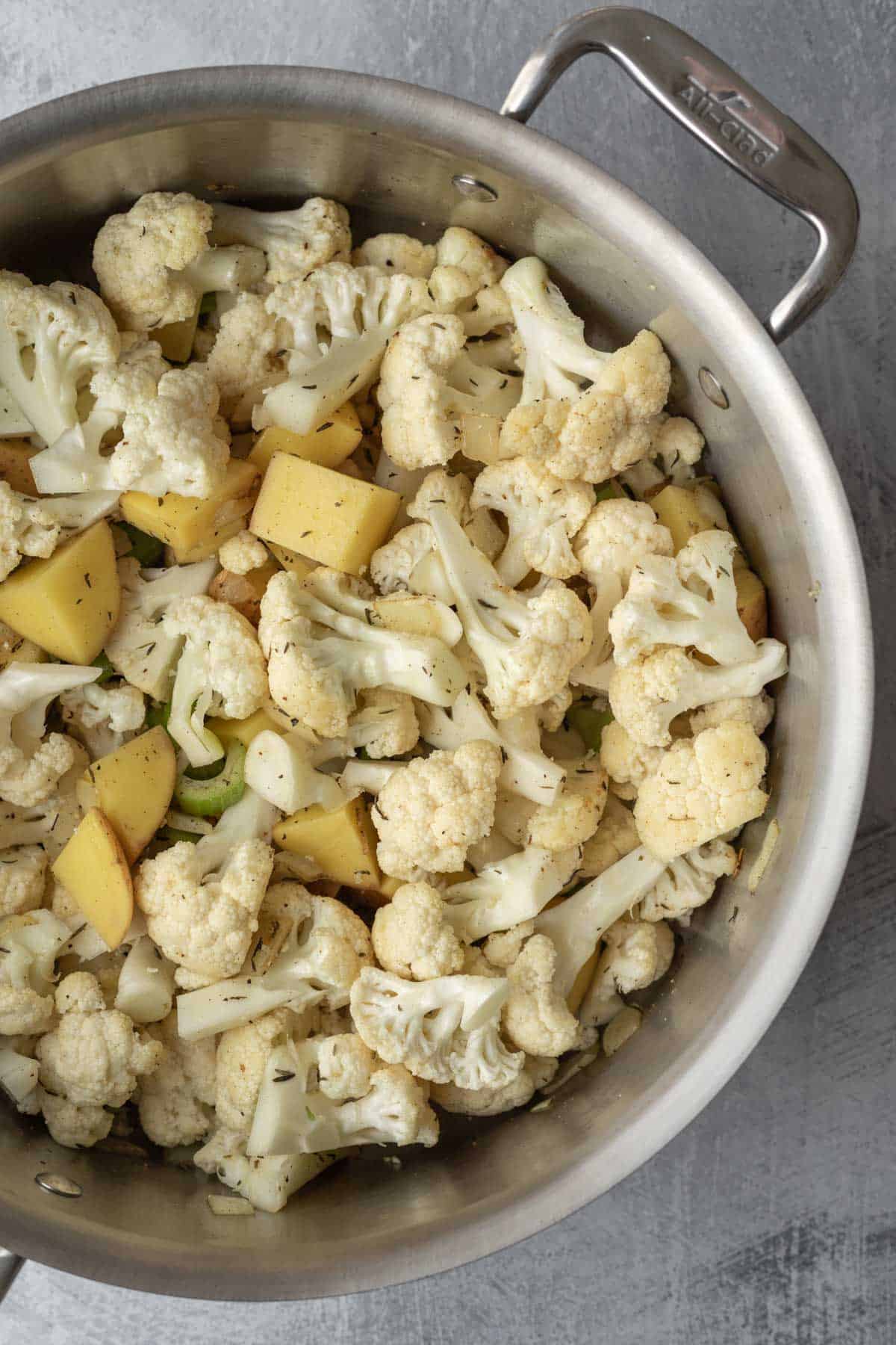 The cauliflower florets and chopped gold potato added to the pot.