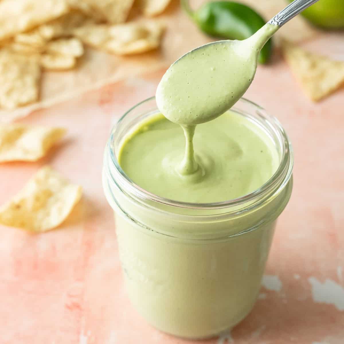 Creamy light green dressing in a jar.