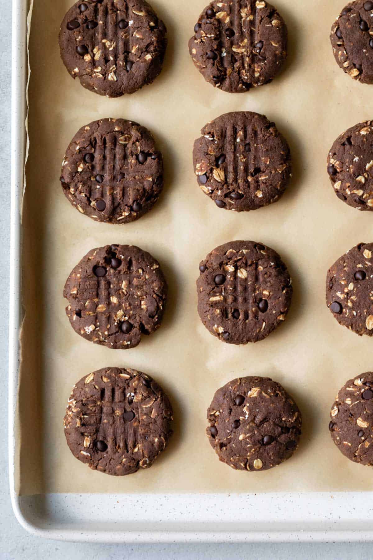 Unbaked cookies lined up on parchment on a baking sheet.