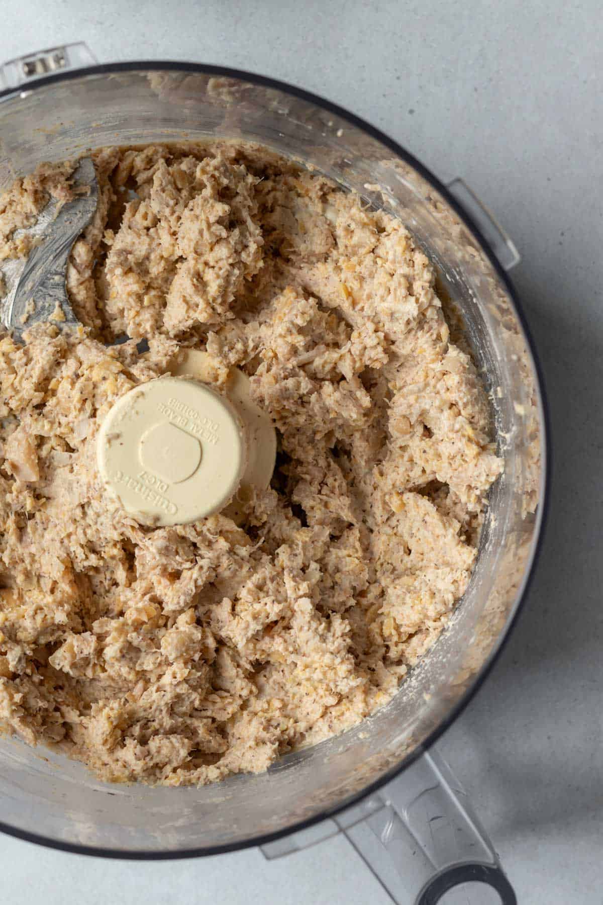 Looking inside food processor at the texture of chickpea tuna salad.