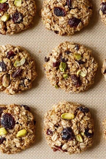 Baked applesauce oatmeal cookies on a silicone baking mat.