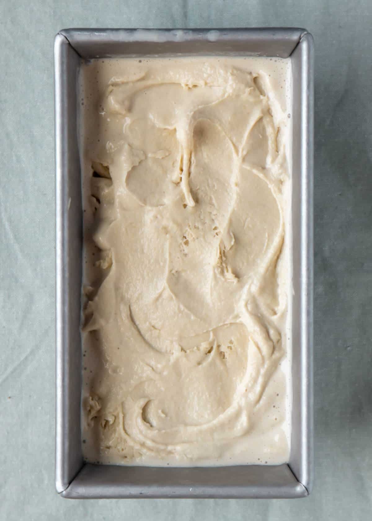 Churned oat ice cream in a loaf pan to be frozen.