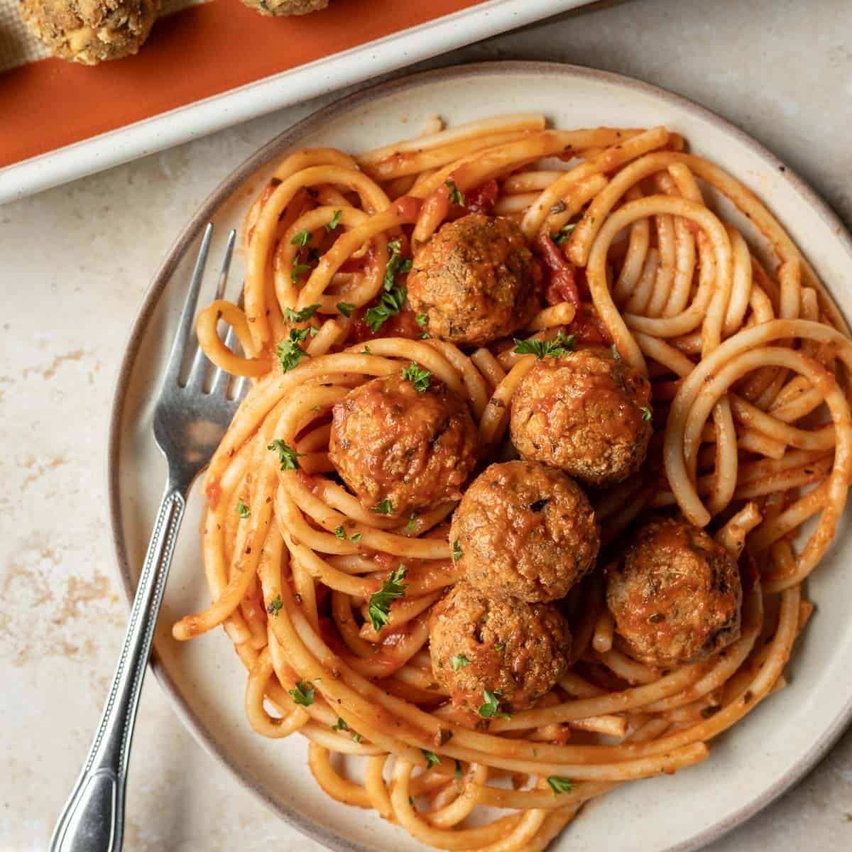 A plate of vegan spaghetti and tofu meatballs.
