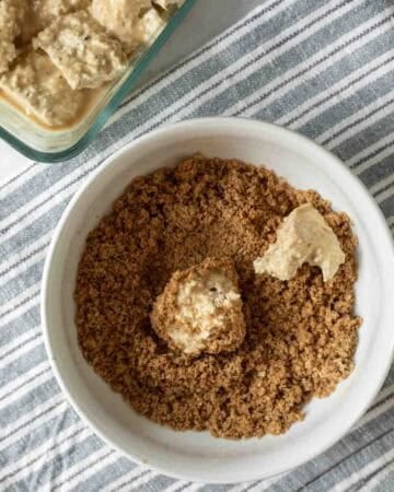 Tossing the marinated tofu nuggets with a crispy nutritional yeast breading.