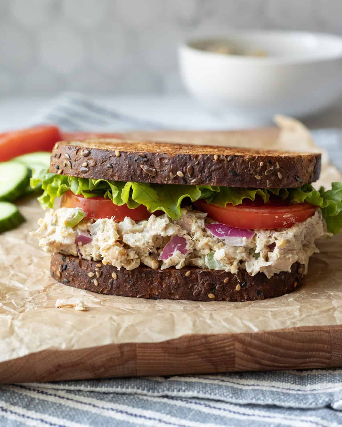 A vegan chicken salad sandwich on whole-grain bread with lettuce and tomato.