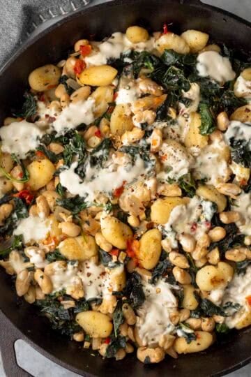 Overhead view of vegan beans and greens with gnocchi.