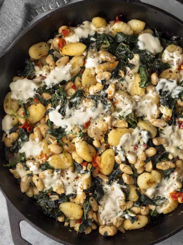 Overhead view of vegan beans and greens with gnocchi.