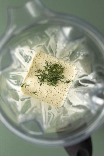 Looking inside a blender at the creamy homemade pickle dressing.