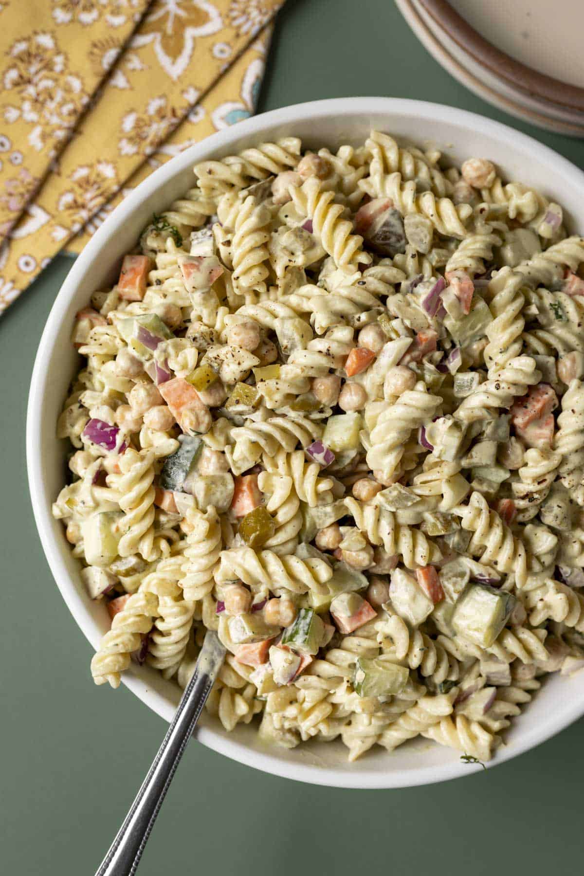 Overhead view of dill pickle pasta salad made with rotini and colorful veggies in a large bowl.