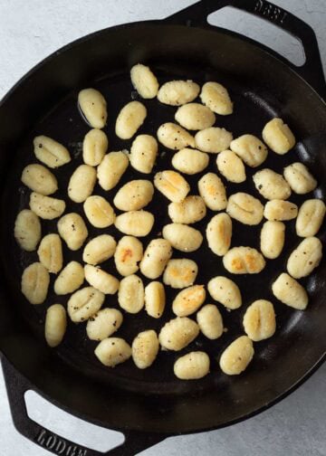 Pan-frying gnocchi in a large skillet.