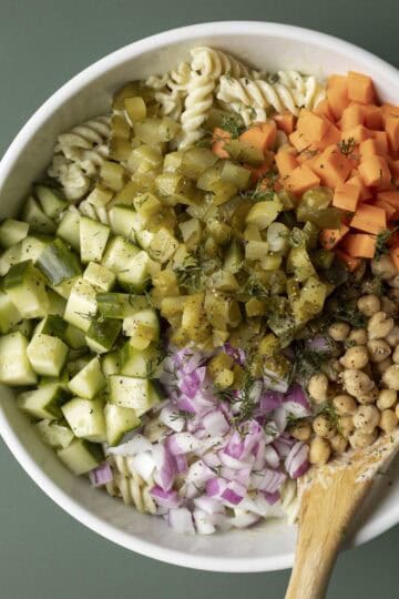 All of the pasta salad ingredients in a bowl before being mixed.