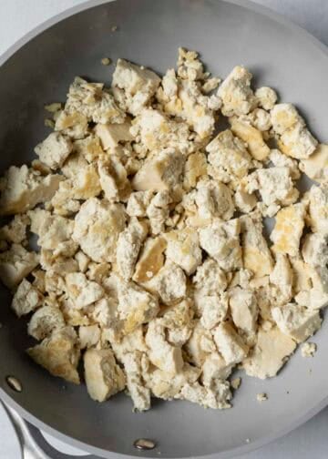 Browning the crumbled tofu in oil before adding the seasoning.