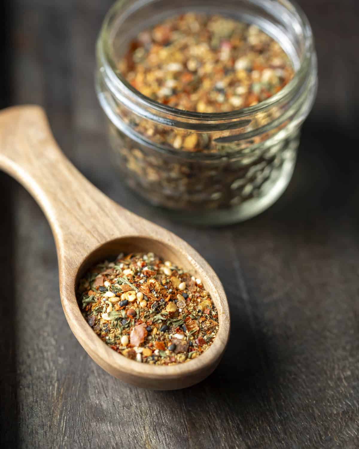 Homemade togarashi seasoning in a jar plus some in a wooden spoon.