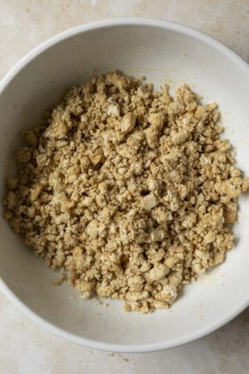 Adding the seasonings and binder to the tofu before forming into patties.