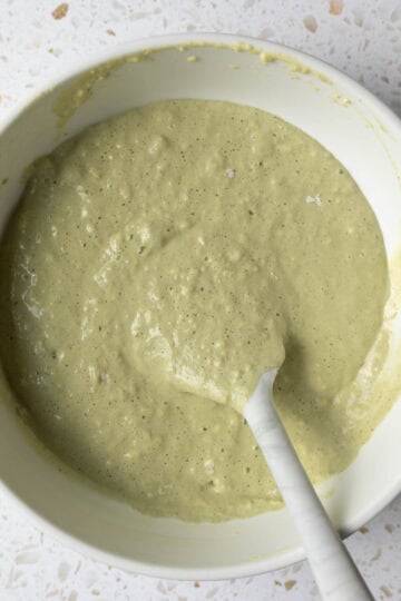 Stirring together the green pistachio pancake batter in a mixing bowl.