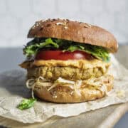 Tofu burger on a bun with mustard, kraut, lettuce, and tomato.