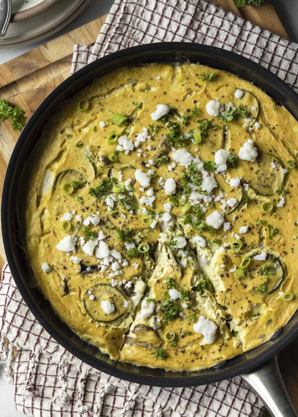 Serving a tofu frittata from a skillet.