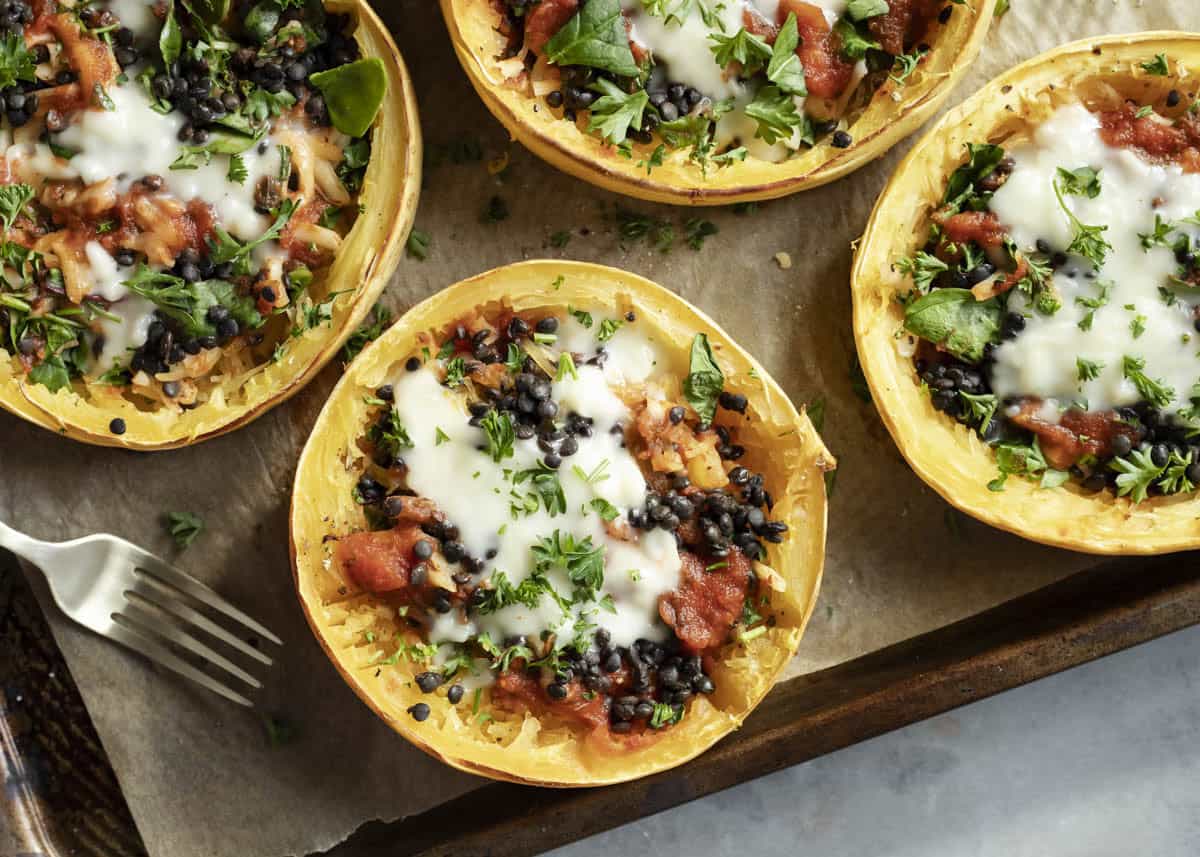 Overhead view of colorful vegetarian squash dish with lentils and melted cashew cheese.