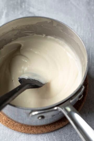 Stirring and heating the mixture on the stovetop until thickened.