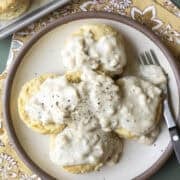 A plate of vegan biscuits smothered with white country gravy.