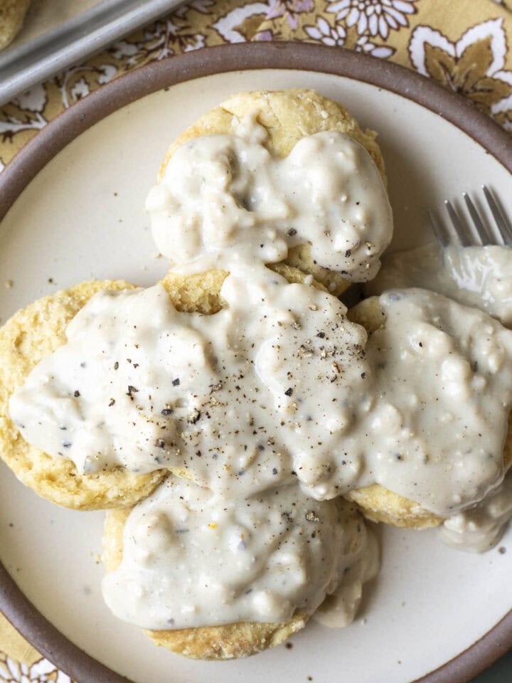 A plate of vegan biscuits smothered with white country gravy.