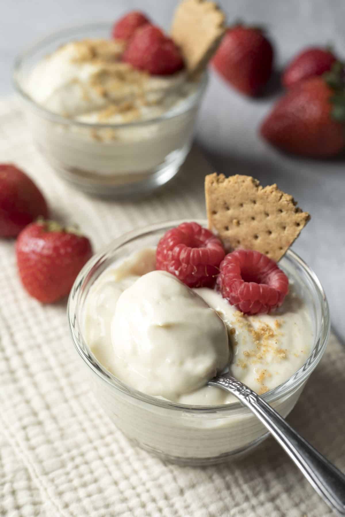 A spoon scooping up a bite of thick and creamy cheesecake pudding.