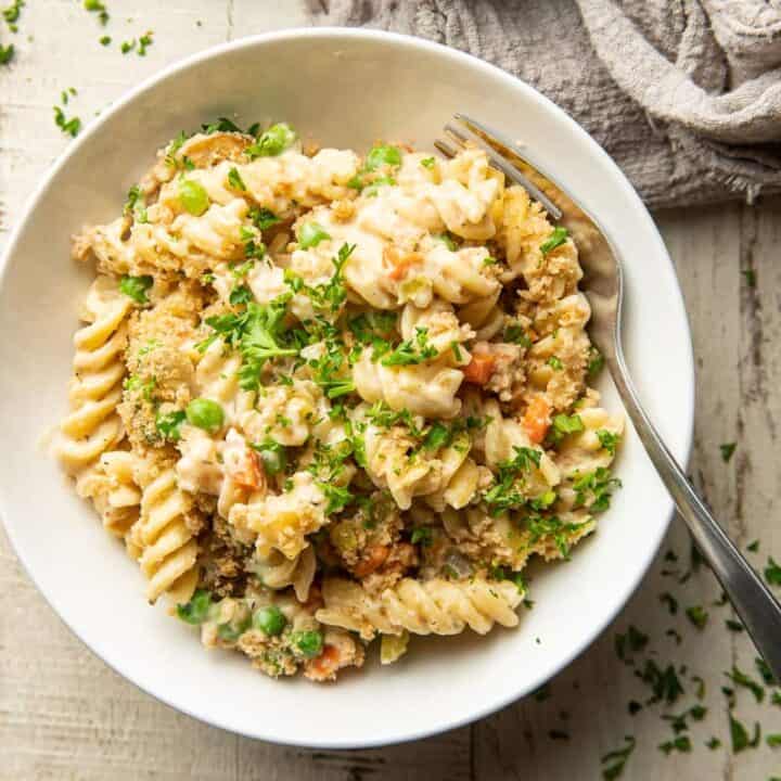 A white bowl filled with creamy rotini pasta casserole.