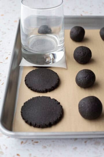Using the flat bottom of a glass to press the cookies into shape.